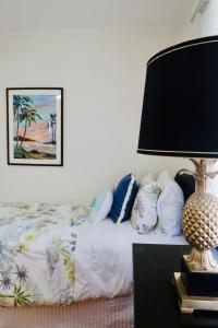 a bedroom with a bed with a lamp and pillows at Halia in Gold Coast