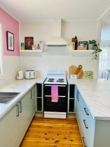 a kitchen with white counters and a stove top oven at Halia in Gold Coast +37 photos