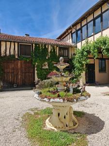 a fountain in a yard in front of a building at Gite du Paradis in Vieuzos