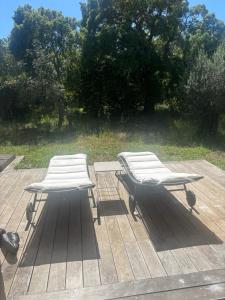 two benches sitting on top of a wooden deck at Maison agostini in Zonza
