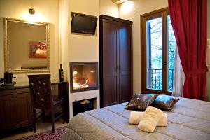 a bedroom with a bed with a fireplace and a mirror at Hotel Filoxenia in Portaria