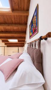ein Schlafzimmer mit einem Bett mit rosa und weißen Kissen in der Unterkunft Loft Bonbon in Cinisi + 15 Fotos