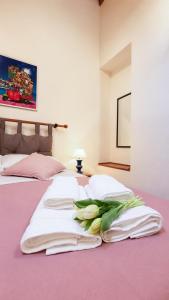 ein Schlafzimmer mit zwei Betten, weißen Handtüchern und Blumen in der Unterkunft Loft Bonbon in Cinisi