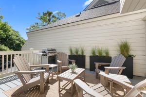 a patio with chairs and a table and a grill at 774 Spinnaker Beach House in Seabrook Island