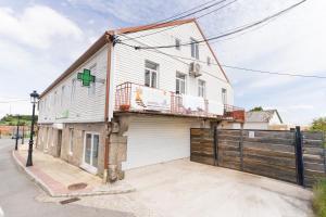 a house with a green cross on the side of it at Casa Bubela - Vía de la plata in Dozón