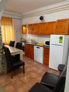 a kitchen with a table and a white refrigerator at A-BB-LAK in Hajdúszoboszló
