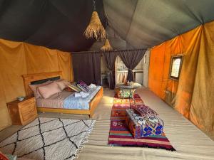 a bedroom with a bed in a tent at Ez-zine Glam in El Aadamna