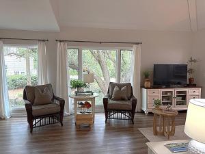 a living room with two chairs and a television at 767 Spinnaker Beach House in Seabrook Island