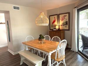 a dining room with a wooden table and chairs at 767 Spinnaker Beach House in Seabrook Island +33 photos