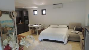 a bedroom with a bed and a kitchen with a table at Villa Studio Cosy Hauteur Vallauris L'Atelier in Vallauris