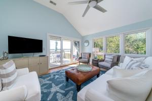 a living room with white furniture and a flat screen tv at 13108 Pelican Watch Villa in Seabrook Island