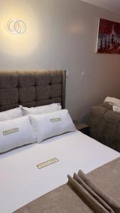 a bed with white pillows and a headboard in a room at Pinnacle Homes 254 - Ruaka in Ruaka
