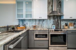 a kitchen with white cabinets and stainless steel appliances at 2105 Bay Pointe Villa in Seabrook Island +29 photos