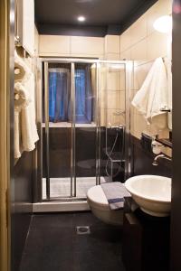 a bathroom with a shower and a toilet and a sink at Hotel Filoxenia in Portaria +157 photos