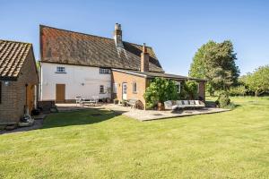 a house with a large yard in front of it at Cutbush Farmhouse in Norwich