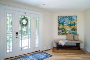 a room with a door and a bench and a painting at 2932 Captain Sams in Johns Island