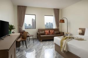 a hotel room with a bed and a couch at Amana Hotel Phnom Penh in Phnom Penh