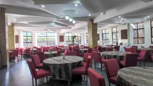 a dining room with tables and red chairs at The Luke Hotel - Roasters in Nairobi