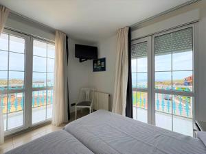a bedroom with a bed and views of the ocean at Hotel Pineda Playa in Noja