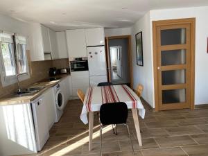 a kitchen with a table and chairs in a room at Cosy et proche de tout in Hendaye +4 photos