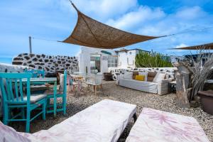 a patio with chairs and furniture and a table at Vista Paraiso, Sea breeze facing the sea in La Oliva