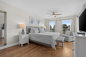a white bedroom with a bed and a chair at 2943 Atrium Villa in Seabrook Island
