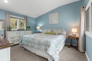a blue bedroom with a bed and a window at 620 Shadowwood in Seabrook Island