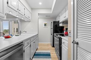 a kitchen with white cabinets and a black refrigerator at 1807 Heron Pt in Seabrook Island