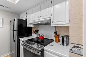 a kitchen with white cabinets and a black refrigerator at 1807 Heron Pt in Seabrook Island