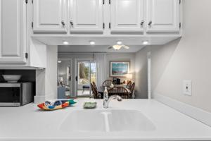 a kitchen with white cabinets and a sink at 1807 Heron Pt in Seabrook Island +24 photos