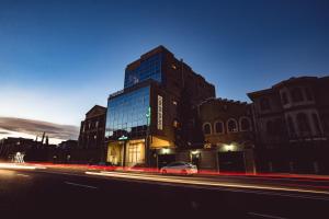 a building with a car parked in front of a street at Admiral Hotel in Baku