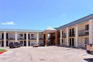 a large building with cars parked in a parking lot at Del Rio Inn TX By Hotel O in Del Rio +47 photos