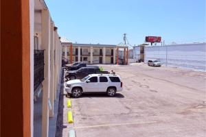 a white car parked in a parking lot next to the ocean at Del Rio Inn TX By Hotel O in Del Rio