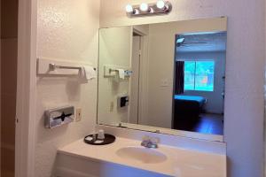 a bathroom with a sink and a large mirror at Del Rio Inn TX By Hotel O in Del Rio