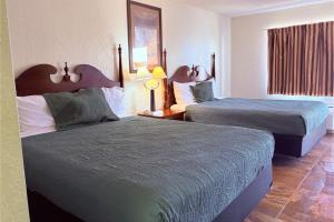 a hotel room with two beds and a window at Del Rio Inn TX By Hotel O in Del Rio