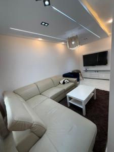 a living room with a white couch and a tv at Escapade urbaine moderne in Sétif