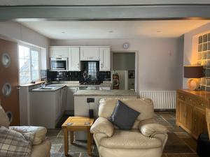a living room with a couch and a kitchen at Stunning coastal cottage in Worle +12 photos