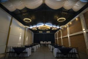 a banquet hall with tables and chairs and a chandelier at Hotel Catedral Boutique Loft in Pasto
