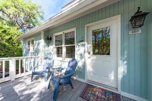 a front porch with two blue chairs and a table at 507 Tarpon Pond Cottage in Johns Island