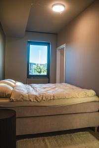 a bedroom with a large bed with a window at Modern apartment with balcony and view in Trondheim