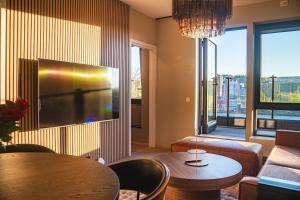 a living room with a couch and a table and a tv at Modern apartment with balcony and view in Trondheim