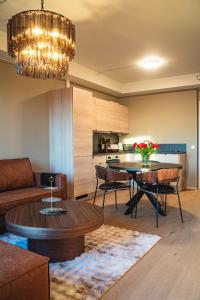 a living room with a table and a kitchen at Modern apartment with balcony and view in Trondheim