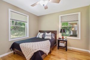 a bedroom with a bed with a ceiling fan and two windows at Cozy Corner in Oswego