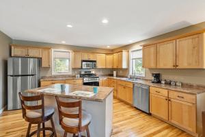 a kitchen with wooden cabinets and a island with bar stools at Cozy Corner in Oswego