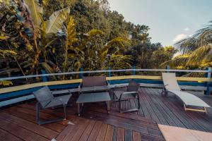 a deck with chairs and tables on a balcony at Haut de lolo in Garnier
