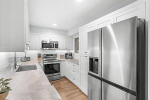 a kitchen with white cabinets and a stainless steel refrigerator at 1128 Summerwind Cottage in Seabrook Island +35 photos