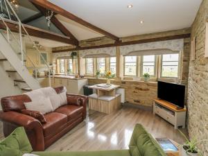 a living room with a couch and a tv at Riverview Cottage in Holmfirth