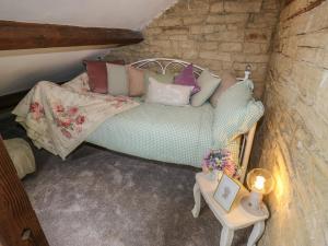 a room with a couch with pillows and a table at Riverview Cottage in Holmfirth
