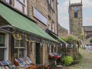 a building with a book store with a clock tower at Riverview Cottage in Holmfirth
