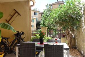 a patio with a table and chairs and a bike at L'AMARILYS chambre d'hôte au coeur du village, terrasse avec vue sur le château in Châteauneuf-du-Pape